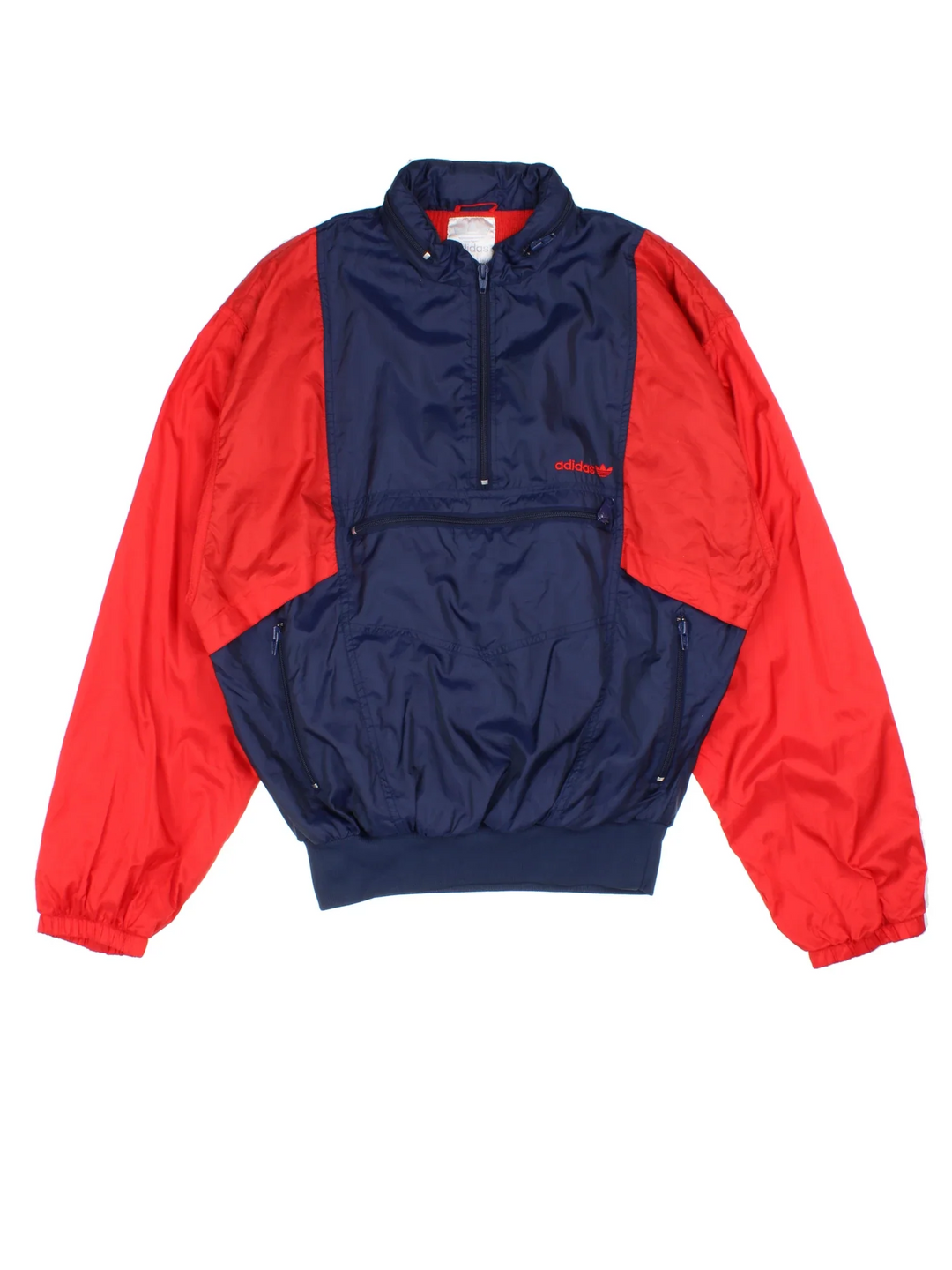 Vintage 90's Adidas Windbreaker Jacket in a blue/red colourway. 1/4 zip fastening, front pocket (which turns into bag), insulated with a brushed jersey lining, and has the logo embroidered on the front.