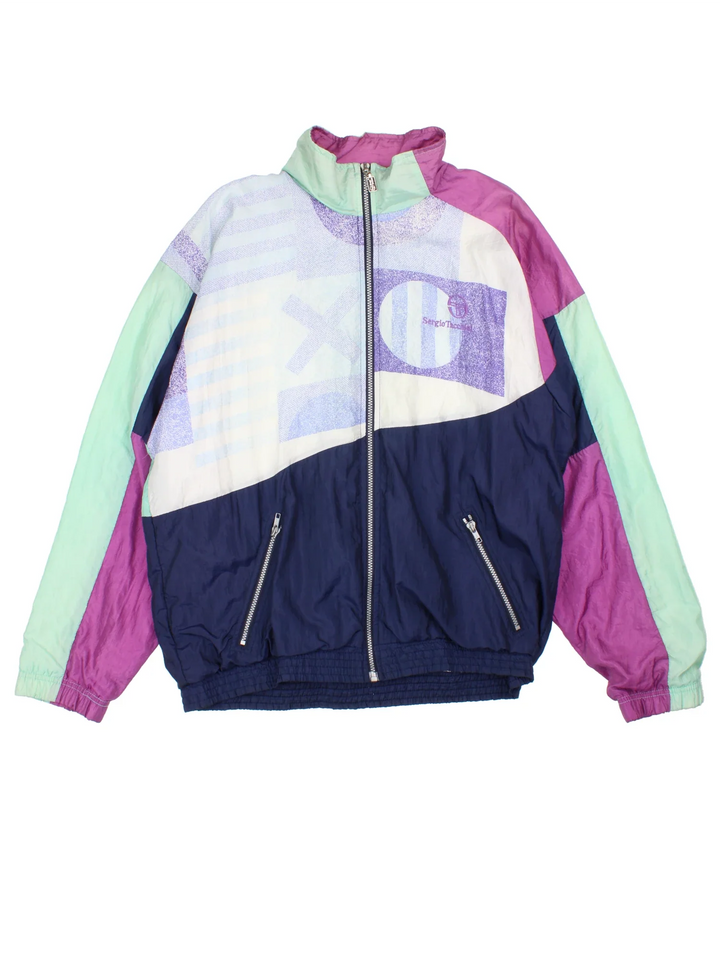 Vintage Sergio Tacchini Shell Jacket in a blue  and purple colourway. Zip up closure and has side pockets, and the logo embroidered on the front.