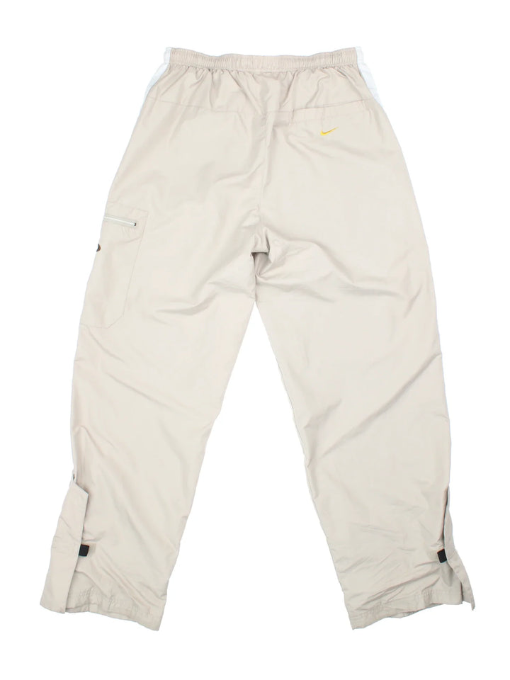 Nike Cargo Trousers in tan colourway. Elasticated waistband with multiple pockets and the logo embroidered on side pocket and back.