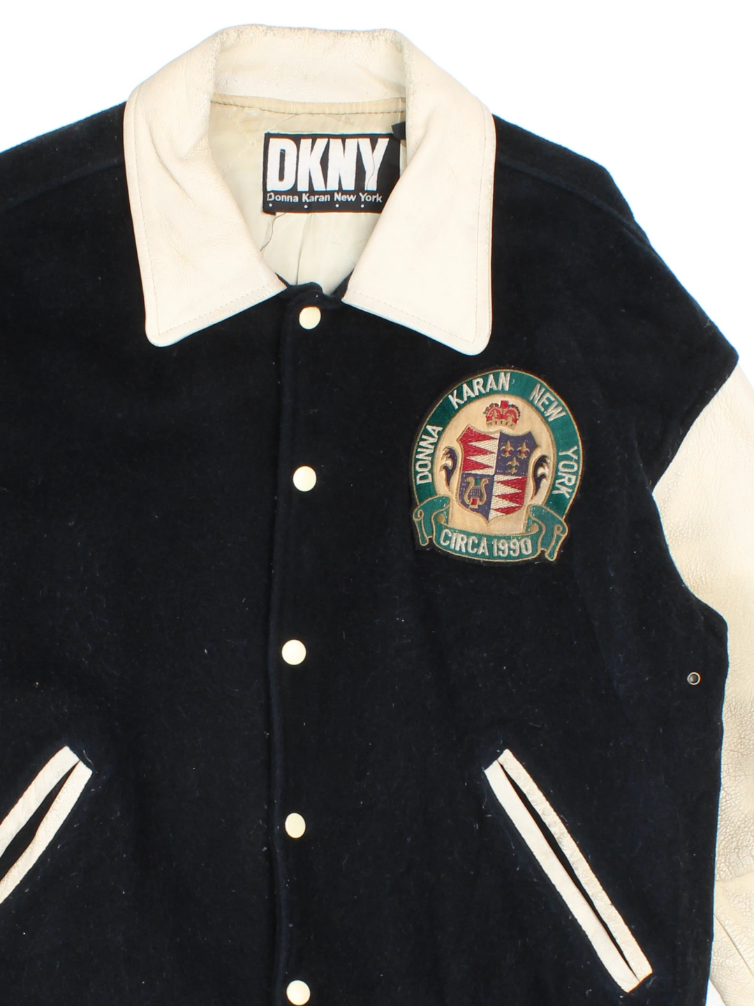 Vintage 90's DKNY black and white varsity jacket with wool body and leather sleeves, features embroidered badges and large spell-out motif on the back 