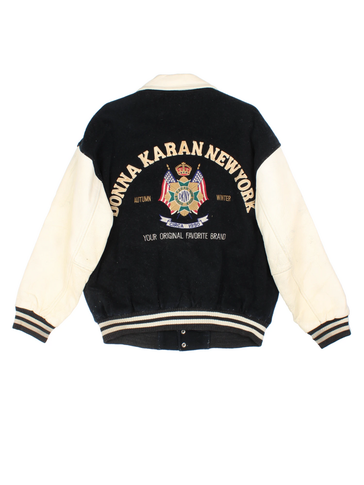 Vintage 90's DKNY black and white varsity jacket with wool body and leather sleeves, features embroidered badges and large spell-out motif on the back 