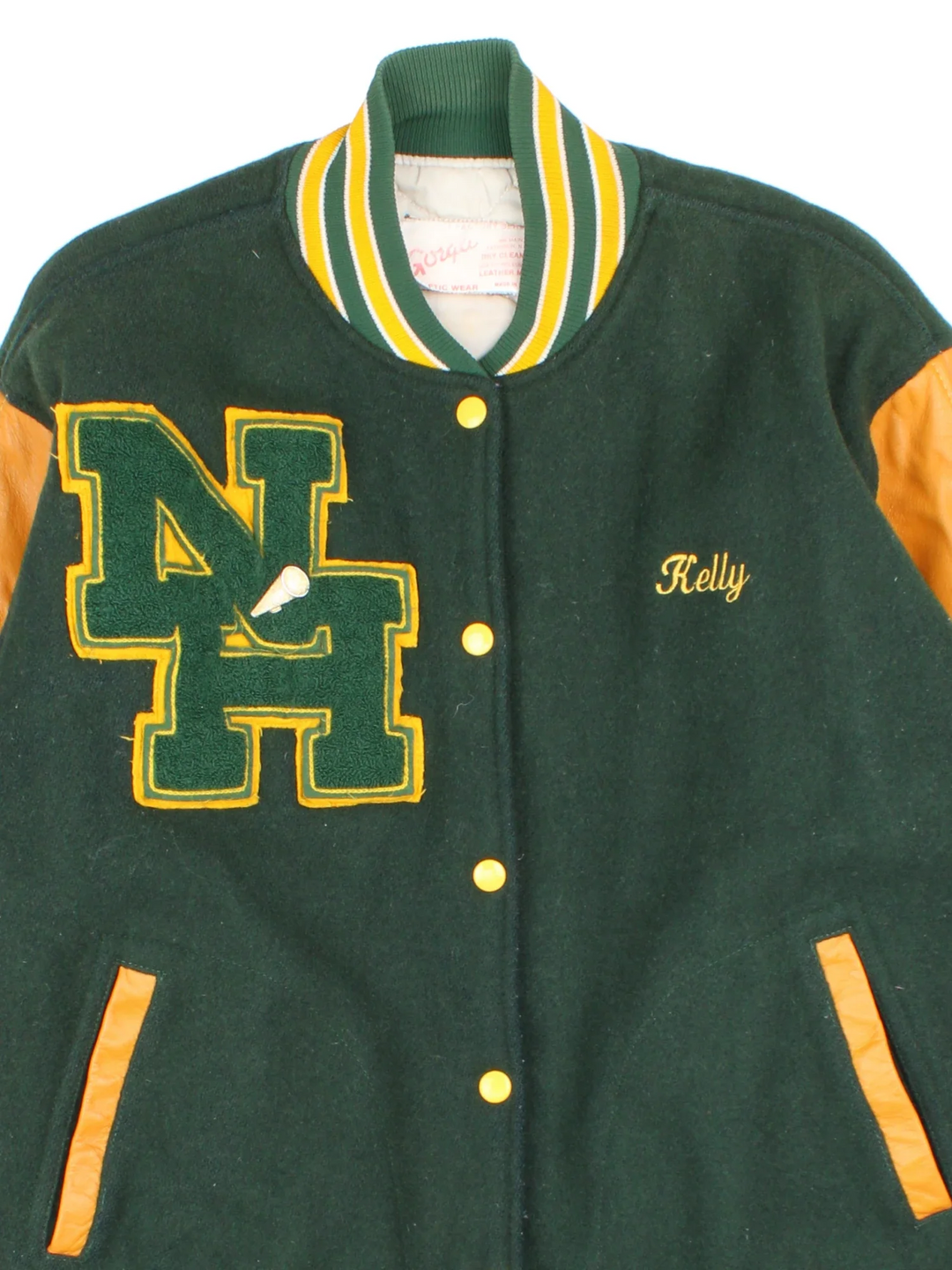 Vintage 2000 N.H.H.S Varsity Jacket in a green/yellow colourway. Features embroidered badges on front and embroidered spell-out on the back. Buttons up and has side pockets, insulated with quilted lining.