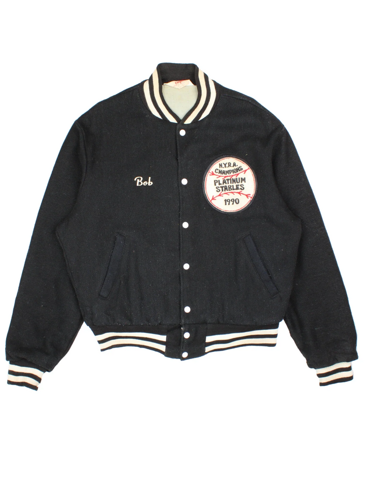 Vintage N.Y.R.A Champions Varsity Jacket in a black/white colourway.  Features embroidered badges on front, contrasts cuffs and collars, buttons up and has side pockets. Insulated with a contrast lining.