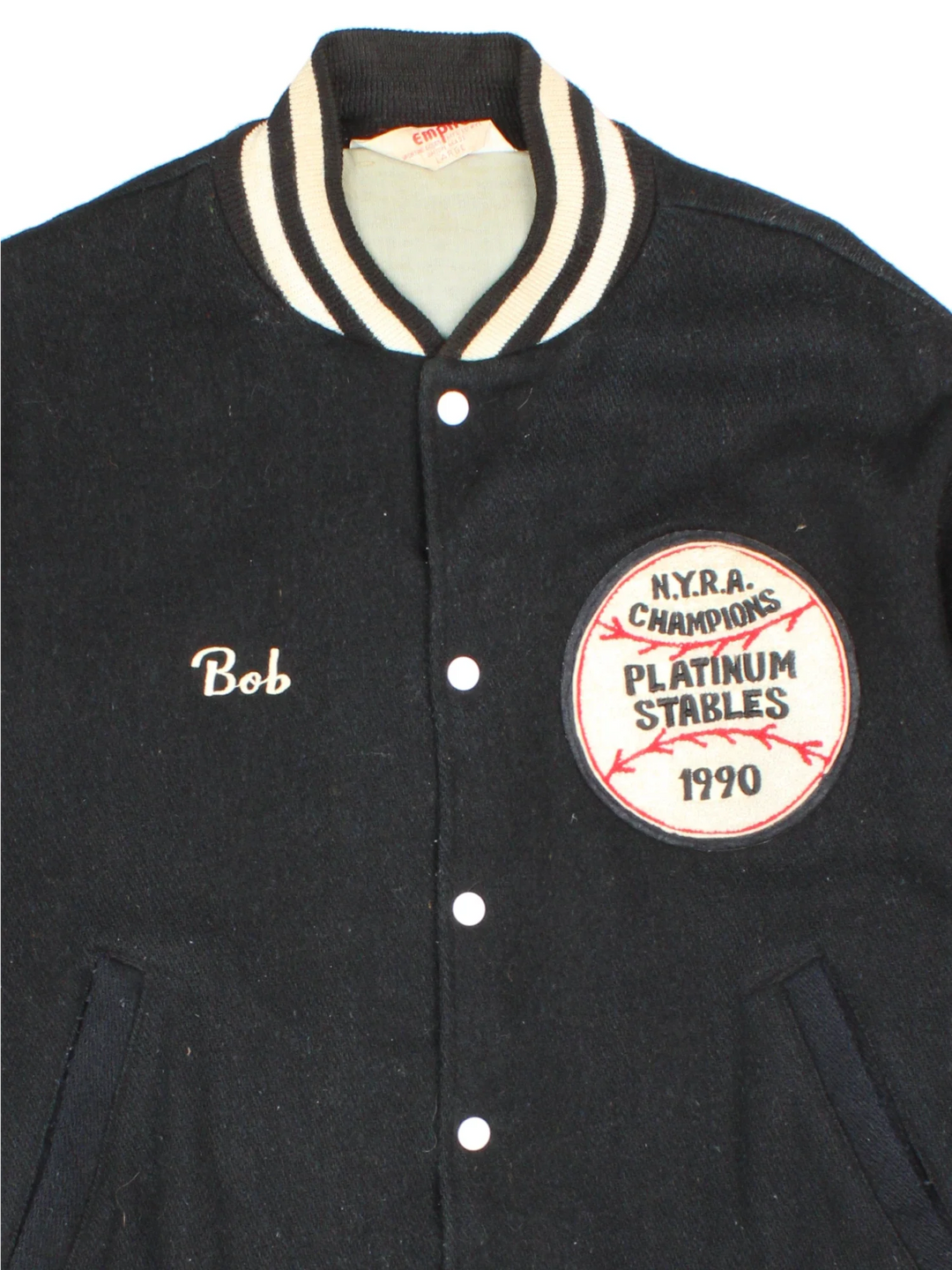 Vintage N.Y.R.A Champions Varsity Jacket in a black/white colourway.  Features embroidered badges on front, contrasts cuffs and collars, buttons up and has side pockets. Insulated with a contrast lining.