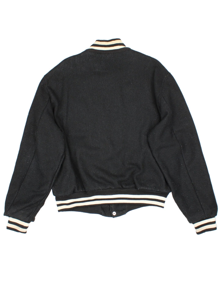 Vintage N.Y.R.A Champions Varsity Jacket in a black/white colourway.  Features embroidered badges on front, contrasts cuffs and collars, buttons up and has side pockets. Insulated with a contrast lining.