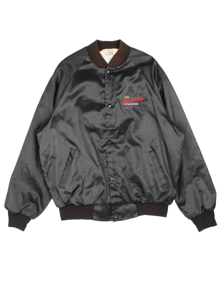 Vintage Chevrolet The Heart Of America Varsity Jacket in a black colourway. Buttons up and has side pockets, and the logo / spell out embroidered on the front and back.