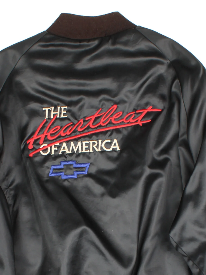 Vintage Chevrolet The Heart Of America Varsity Jacket in a black colourway. Buttons up and has side pockets, and the logo / spell out embroidered on the front and back.
