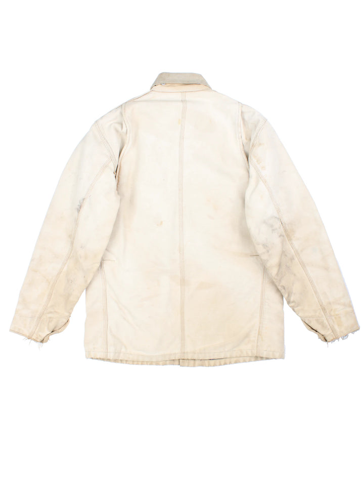 Vintage 70's Carhartt Distressed Chore Jacket in a tan colourway. Buttons up and has multiple pockets, blanket lining, corduroy collar, and has the logo embroidered on the front.