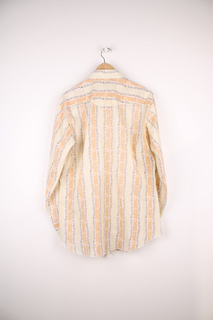 Pale yellow floral patterned short-sleeved shirt by HBarC with two flap pockets and pearl-effect snap closure. 