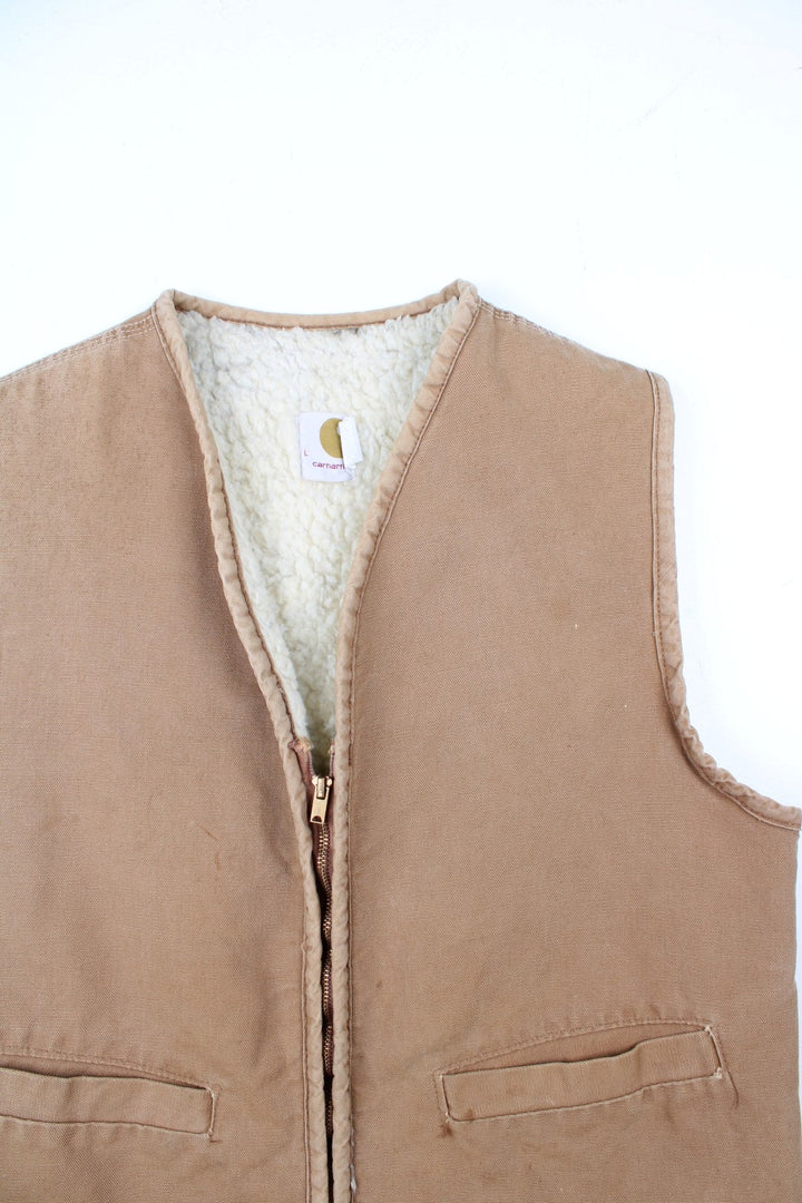 Vintage Carhartt Gilet in a tan colourway. Zip up with double pockets on front, insulated with a fleece lining.