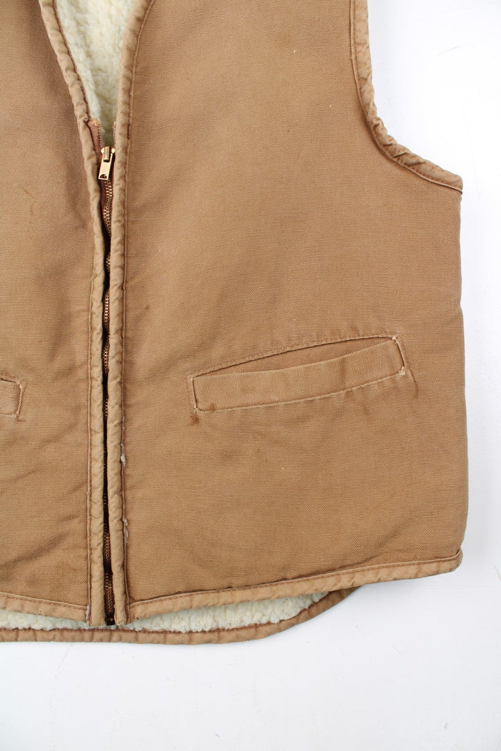 Vintage Carhartt Gilet in a tan colourway. Zip up with double pockets on front, insulated with a fleece lining.