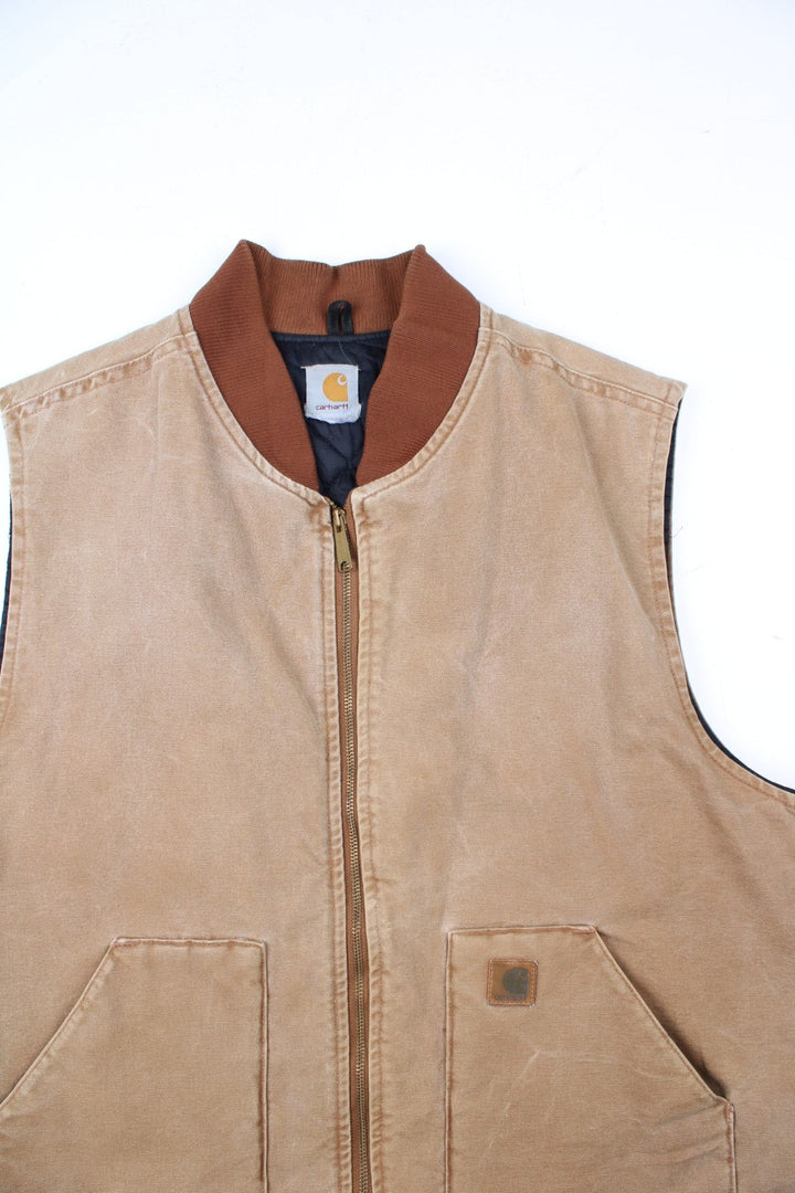 Vintage Carhartt Gilet in a tan colourway. Zip up with double pockets on front, insulated with a quilted lining and classic logo on front.
