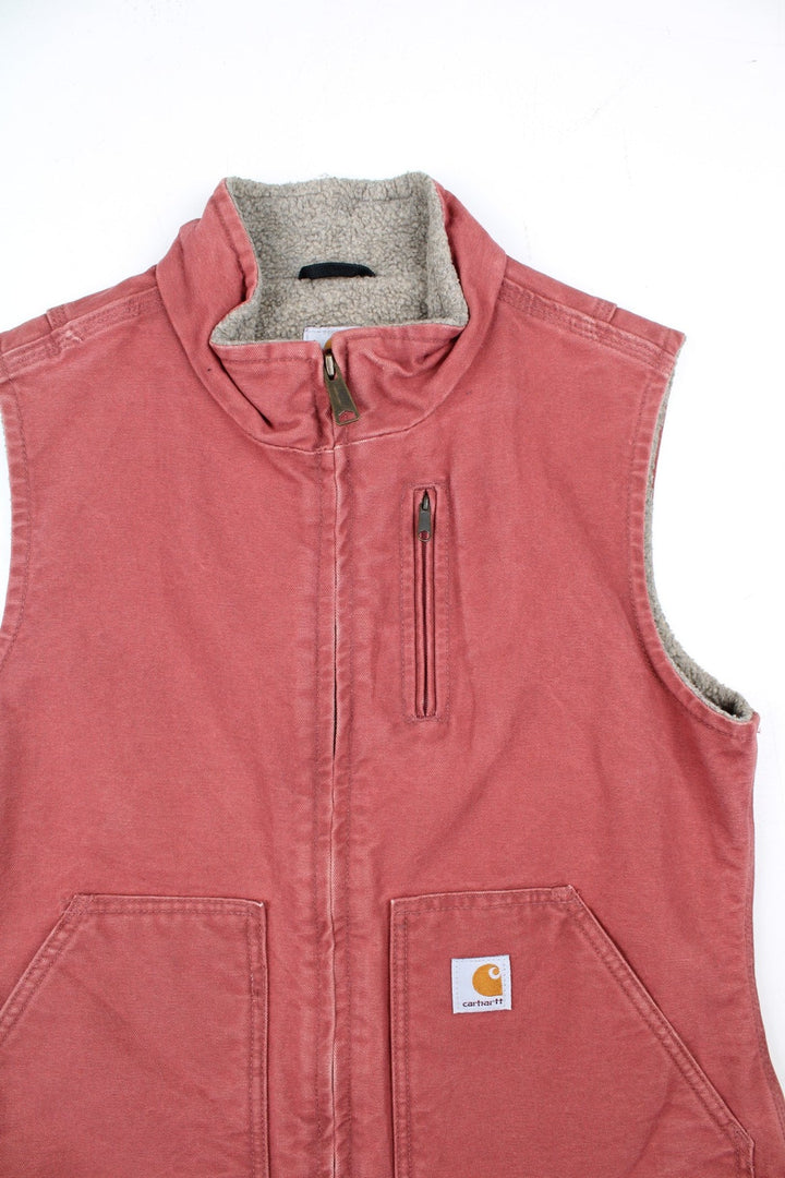 Vintage Carhartt Gilet in a pink colourway. Zip up with double pockets on front, insulated with a sherpa lining and classic logo on front.