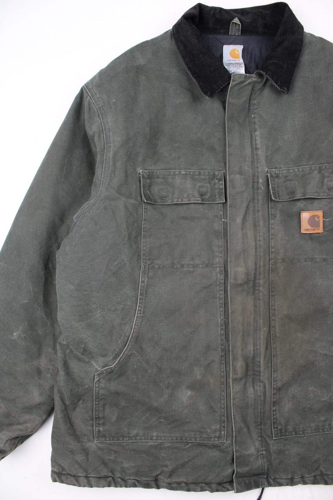 Carhartt Arctic Jacket in a green colourway with a black corduroy collar. Zips up and has multiple pockets, insulated with a quilted lining, and has the logo embroidered on the front.