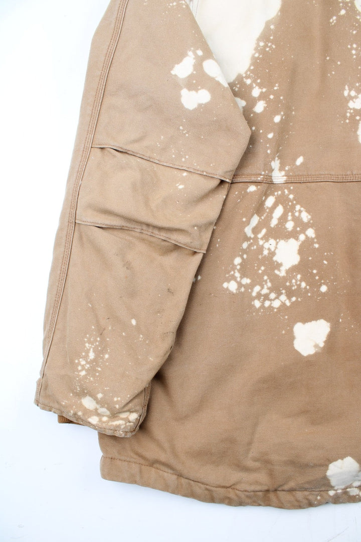 Vintage Carhartt Arctic Jacket in a tan brown colourway. Zips up and has multiple pockets, insulated with a quilted lining, and has the logo embroidered on the front.