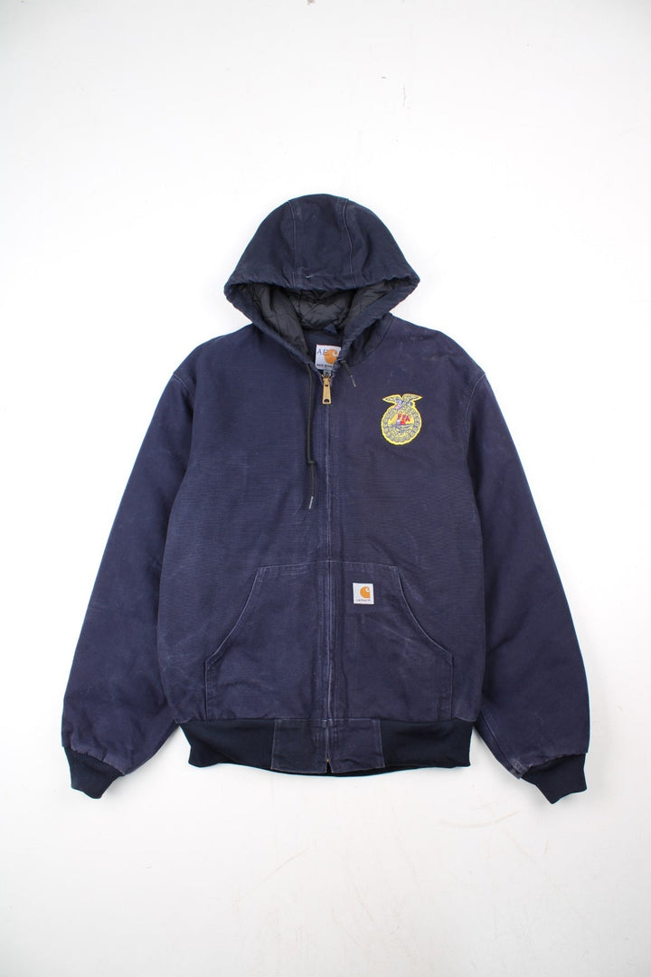 Vintage Carhartt FFA Agricultural Education Active Jacket in a blue colourway. Zips up and has side pockets, insulated with a quilted lining, and has the logo embroidered on the front alongside the FFA logo.