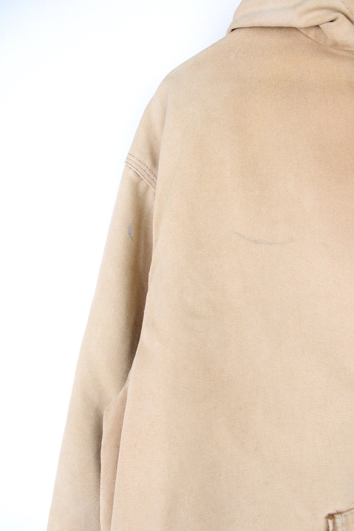 Vintage Carhartt Active Hooded Jacket in a tan colourway. The jacket has two front pockets, a gold zip to close and the Carhartt logo stitched onto the front. 