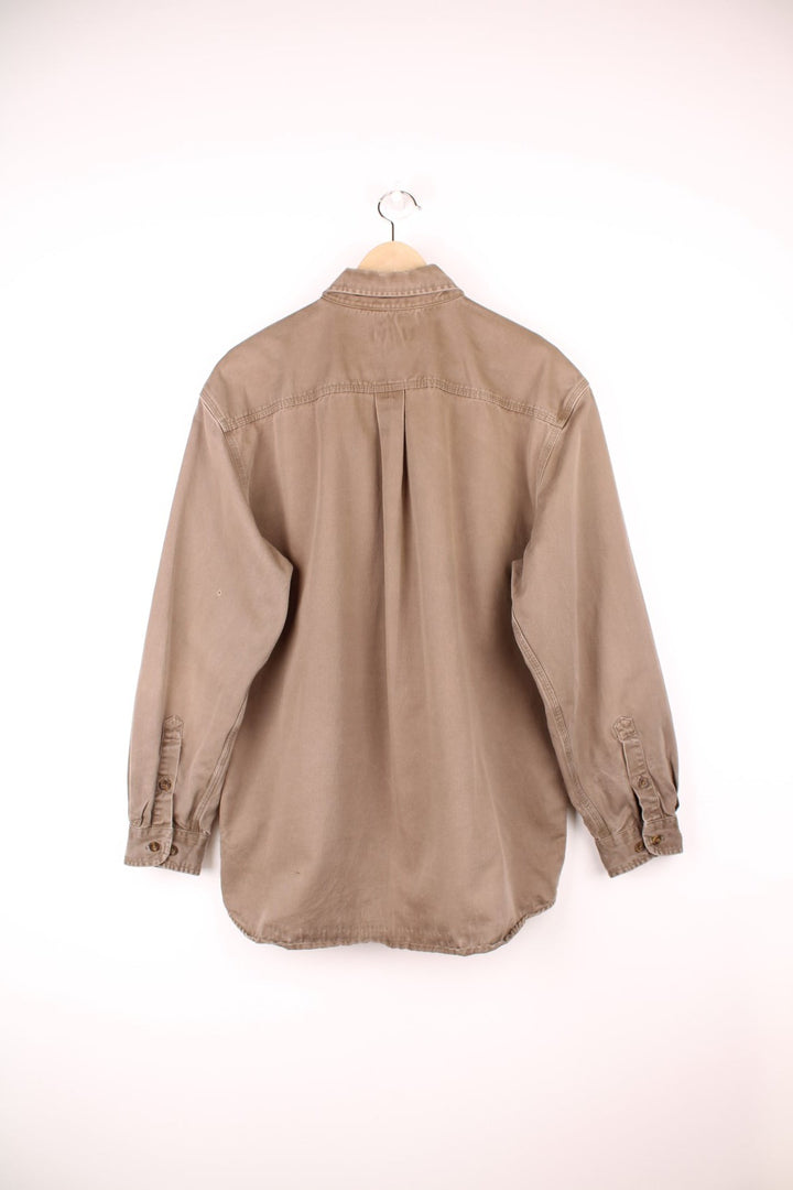Carhartt brown canvas shirt. Features chest pockets and embroidered leather logo.