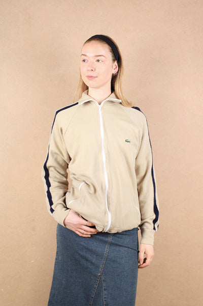 Vintage 1980's Lacoste tan zip through tracksuit top, with navy blue details on the sleeve and signature croc logo on the chest