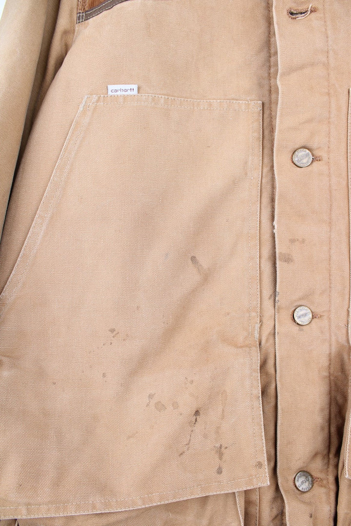  Hunting Jacket in a  browwn colourway with cordurory collar and shoulder pads. Buttons up and has multiple utility pockets including a big detachable pouch pocket on the back, insulated with a blanket lining, and has the logos embroidered on the front.