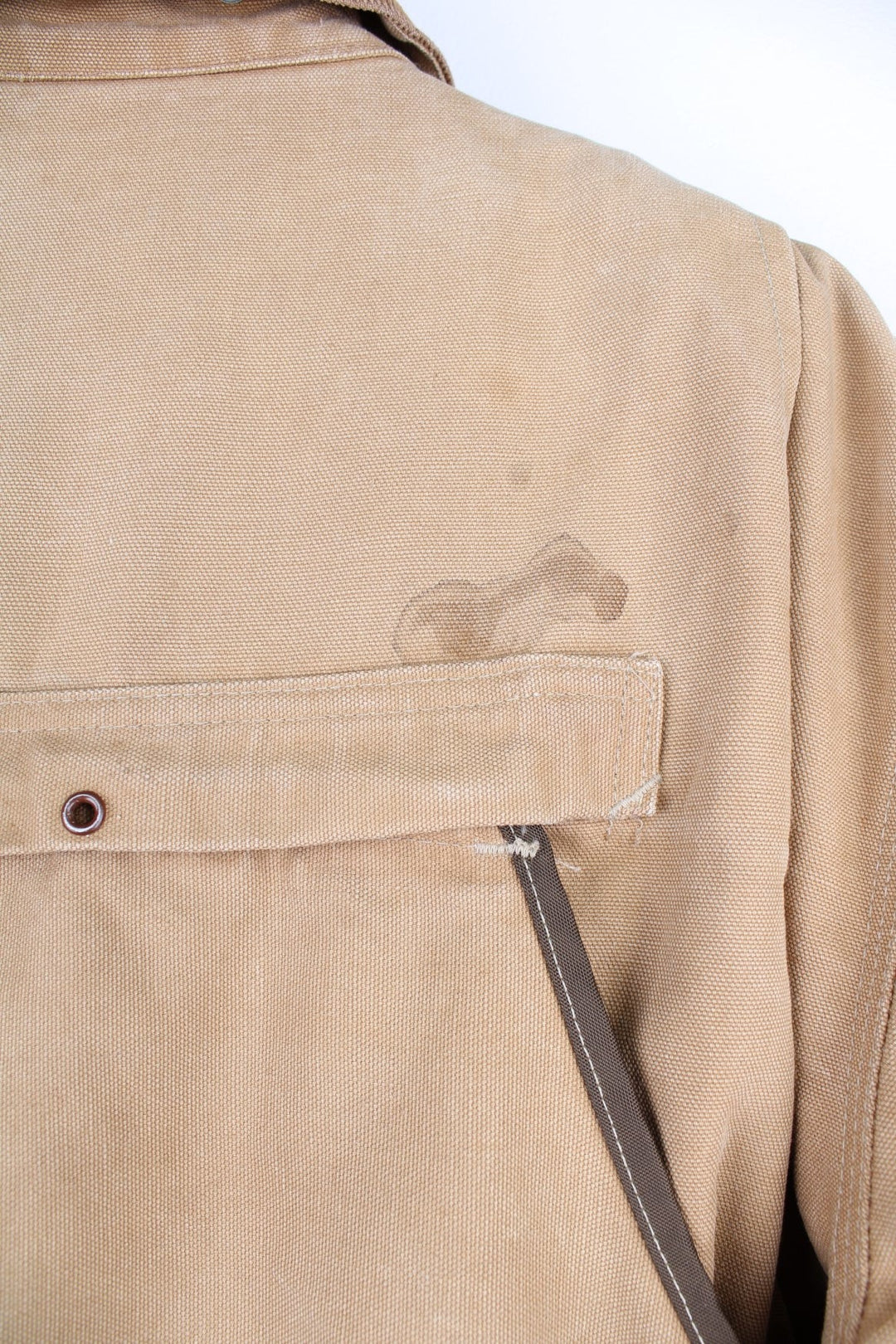  Hunting Jacket in a  browwn colourway with cordurory collar and shoulder pads. Buttons up and has multiple utility pockets including a big detachable pouch pocket on the back, insulated with a blanket lining, and has the logos embroidered on the front.