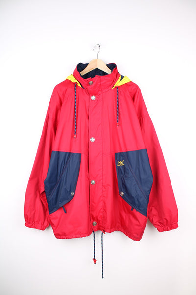 Red, blue and yellow Helly Hansen, windbreaker jacket with foldaway hood and embroidered logo on the pocket.