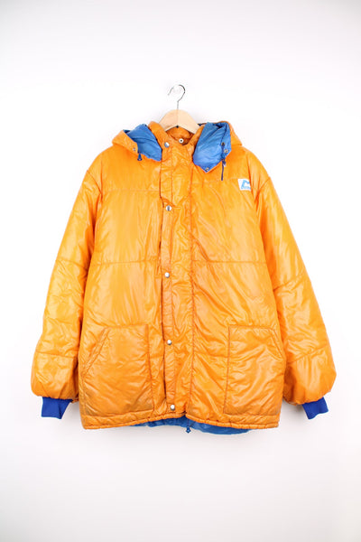 Vintage Mountain Equipment zip through puffer jacket in orange and blue with popper fastenings. Features embroidered logo and detachable hood.
