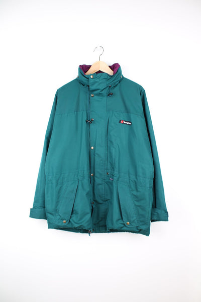 Green Berghaus zip through jacket. Features embroidered logo on the chest and pack away hood. 