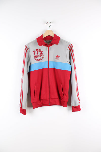 Vintage red and grey Argentat Judo Club tracksuit top. Features embroidered logo on the chest, Argentat logo on the left and the back, signature 3 stripes down the arms and a blue stripe feature
