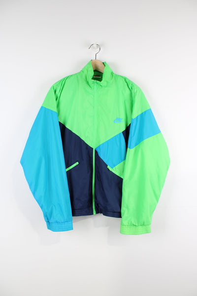 Vintage Nike green tracksuit top with embroidered logo on the chest and blue panelling features.