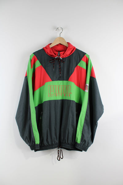 Vintage 80s black puma pullover tracksuit jacket with quarter zip. Features central logo, green and red panelling, and a pack away hood.