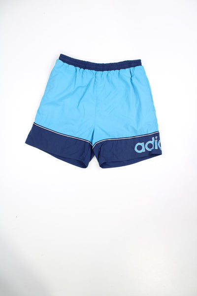 Blue two toned Adidas swim shorts with elasticated waist and drawstring. Features printed spell out logo.
