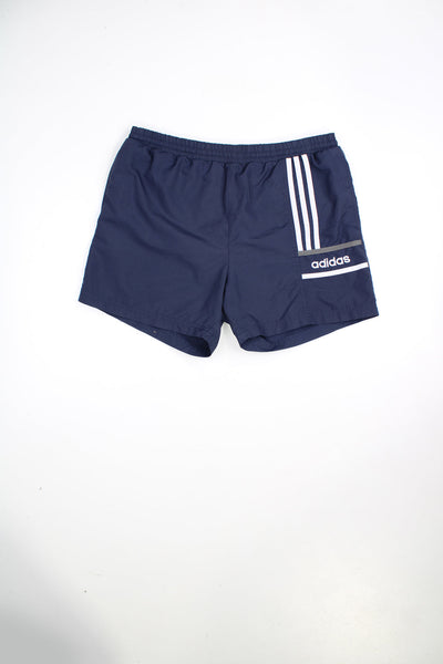 Vintage 90s Adidas shorts with elasticated waist and drawstring. Features signature three stripes and embroidered logo.
