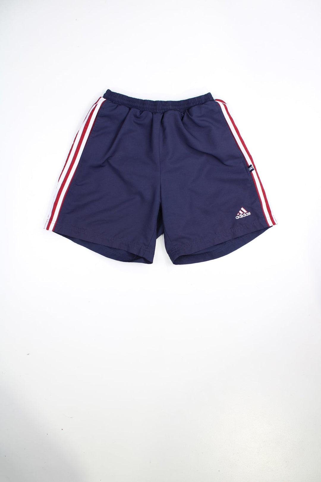 Blue and red Adidas shorts with elasticated waist and drawstring. Features signature three stripes and embroidered logo.