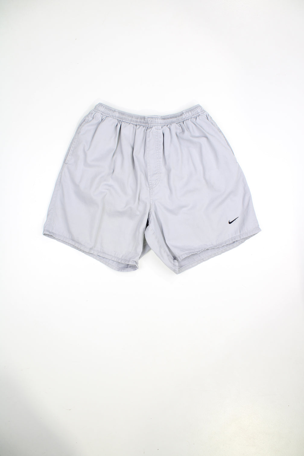 Grey Nike shorts with elasticated waist and drawstring. Features embroidered logo. 