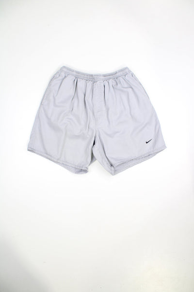 Grey Nike shorts with elasticated waist and drawstring. Features embroidered logo. 