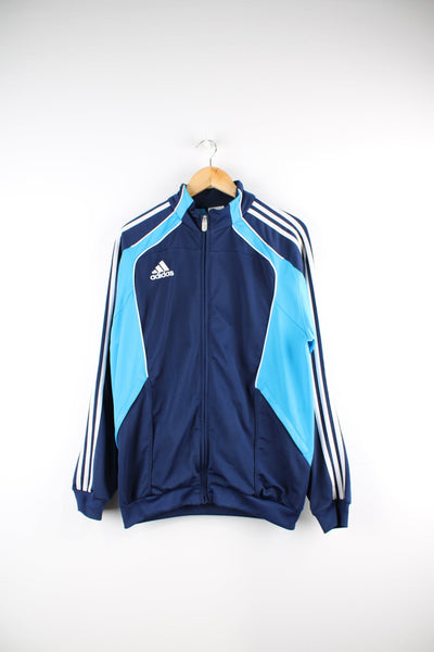Blue Adidas tracksuit top. Features embroidered logo on the chest and signature three stripe detail down each sleeve.