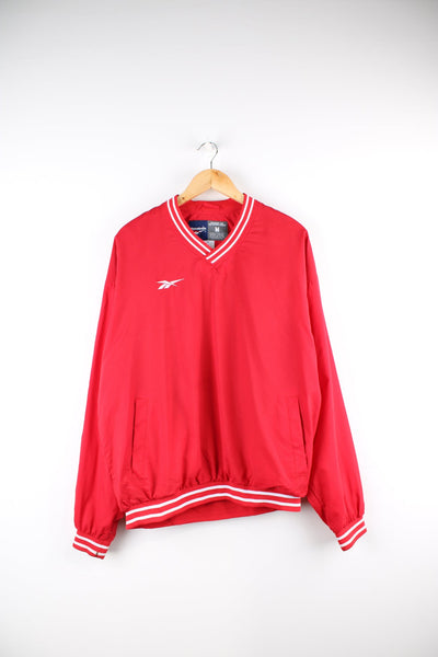 Red Reebok drill top with embroidered logo on the chest.