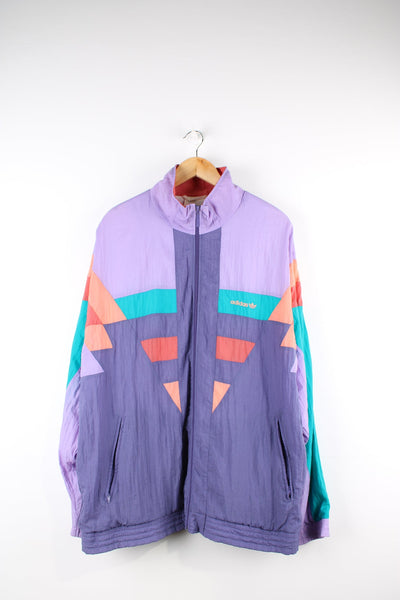 Vintage 80s Adidas shell jacket in purple, orange and green. Features embroidered logo on the chest.