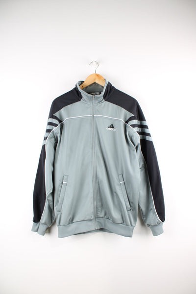 Vintage 90s Adidas tracksuit top in grey and black. Features embroidered logo on the chest and back, and stripe detailing on each sleeve.