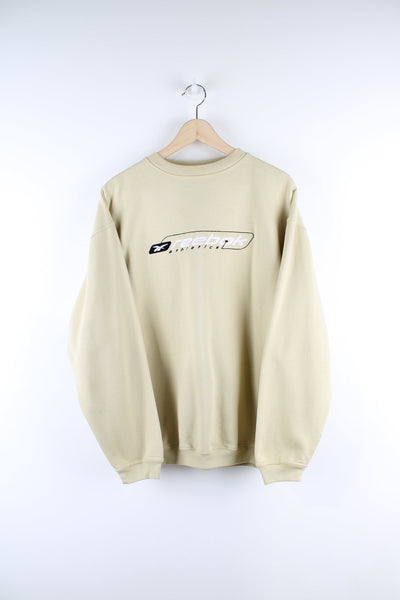 Vintage Reebok sweatshirt in tan. Features embroidered logo across the chest.