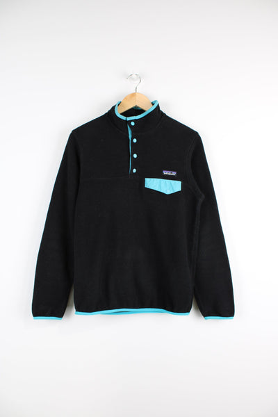 Patagonia Synchilla fleece in black features snap t closure and embroidered logo on the chest