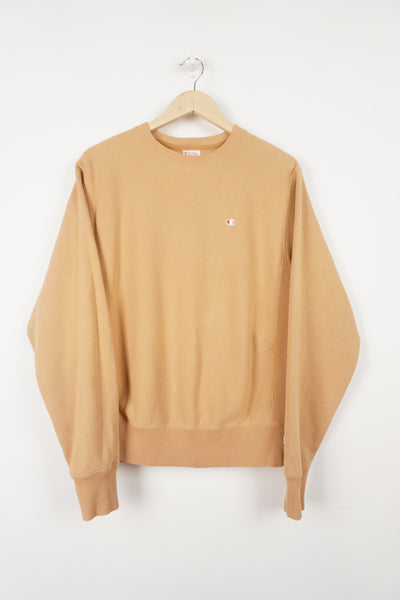 Orange sweatshirt with embroidered Champion logo on the chest and arm. 