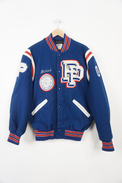 Vintage Patriots Wrestling wool varsity jacket in blue. Features embroidered details and wrestling themed pins 
