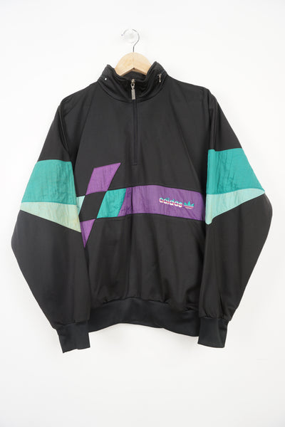 Vintage 1990s Adidas black panelled 1/4 zip tracksuit top. With embroidered logo on the chest and foldaway hood