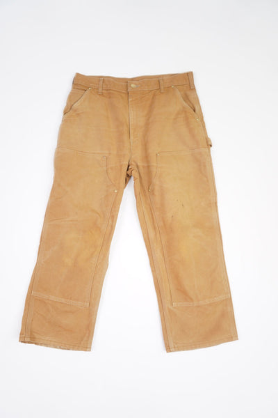 Tan Carhartt heavy duty cotton carpenter jeans with multiple pockets and double knee