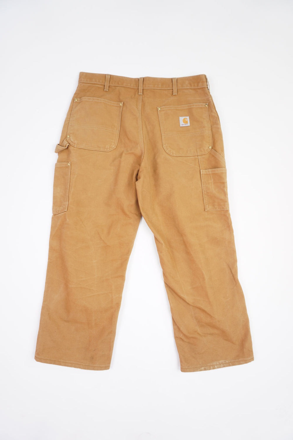 Tan Carhartt heavy duty cotton carpenter jeans with multiple pockets and double knee