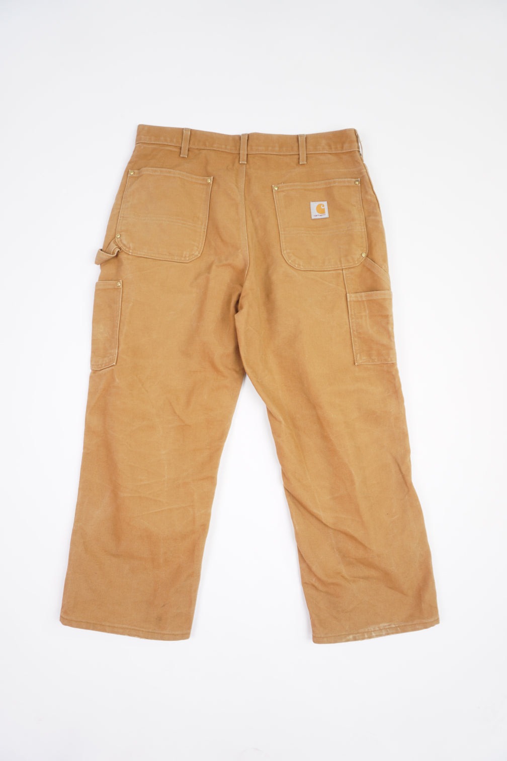 Tan Carhartt heavy duty cotton carpenter jeans with multiple pockets and double knee