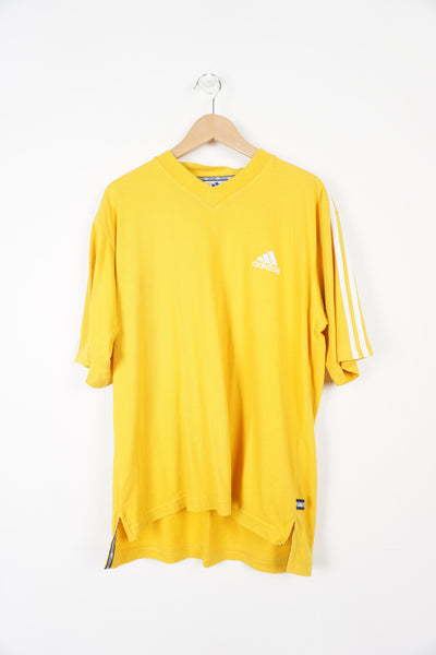 All yellow Adidas t-shirt with logo on chest and three stripes on arms