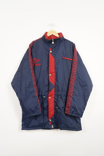 Vintage red & blue Umbro coat with embroidered logo on the chest , foldaway hood and ribbon down sleeves 